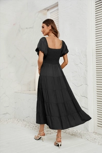 Détail de la texture tissée et de la taille ajustée au dos de cette robe maxi noire