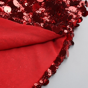 Détail de paillettes rouges haute densité sur tissu mesh pour une robe de Noël licou