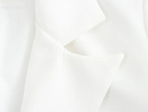 Close-up of elegant white blazer lapel showing smooth woven fabric texture and structure