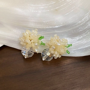 Close-up of handmade cream floral beaded earrings with transparent faceted drop charms