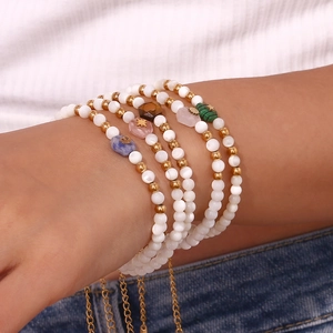 Bohemian bead bracelet set with white pearls and colorful gemstone pendants on wrist