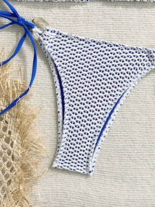 Detail of blue and white crochet bikini bottoms with side ties and marble rings