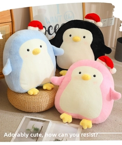 Detail of cute plush penguin toys in blue black and pink with Santa hats Christmas gifts