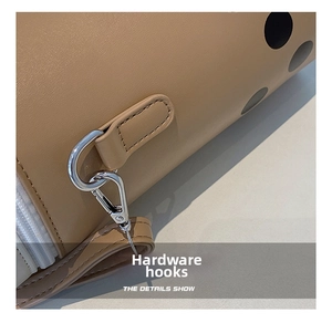 Close-up macro view of the silver hardware hook on a stylish beige milk tea bag