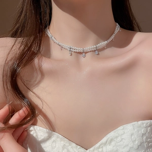 Detail of double-layer pearl choker with teardrop zircon pendants on model neck
