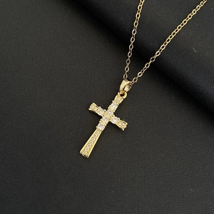 Collier croix pour femme avec zircons blancs sur chaîne dorée fond noir