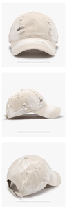 Detail showing distressed holes and beige marble tie-dye texture on a baseball cap