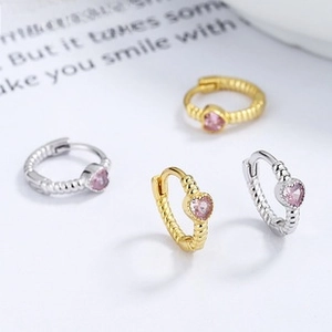 Detail of 925 silver heart earrings with pink zircon and vintage twisted metal texture