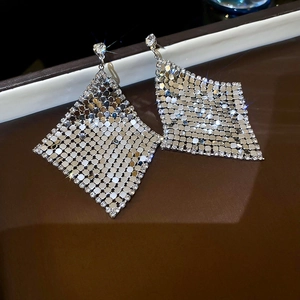 Macro shot of silver diamond-encrusted rhombic mesh earrings with sparkling starburst effect