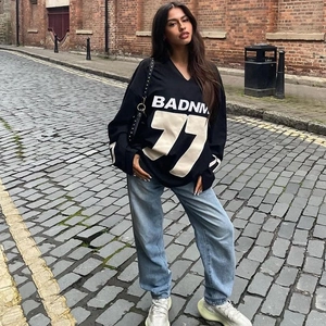 Oversize black long sleeve sweatshirt with BADNM 77 print and loose blue jeans