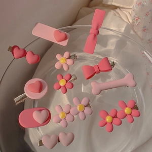 Pink resin hair clips set with heart and flower designs on a glass plate decoration