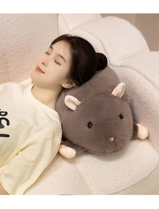 Close-up of a soft grey hamster plush pillow used as a cozy headrest by a woman