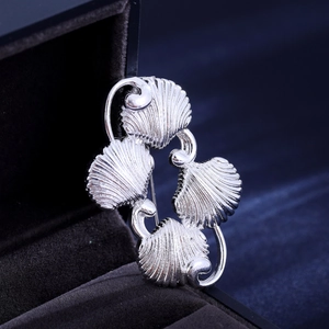 Vintage silver-tone shell brooch with four connected shells in a velvet jewelry box