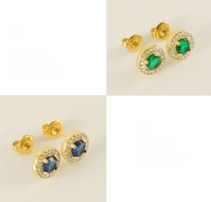 Detailed macro view of 18K gold plated earrings with emerald and sapphire zircon settings