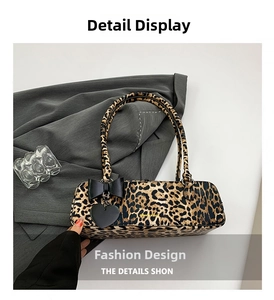 Detail view of leopard print shoulder bag with black leather bow and heart charm detail