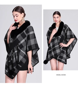 Detail of knit poncho featuring faux fur collar and black grey plaid pattern
