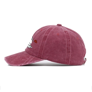 Detail of vintage washed baseball cap featuring rose embroidery and distressed brim