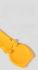 Macro detail of the bright yellow pet feeder spoon with wide concave curved surface