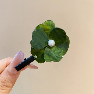 Détail de la pince à cheveux fleur marbre vert foncé avec perle et petit strass