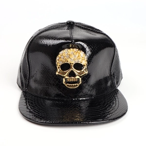 Faux crocodile leather snapback hat in black featuring a large golden skull and flat brim