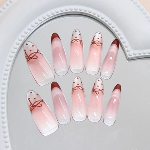 Pink French almond press-on nails with red bow, polka dots and gradient finish