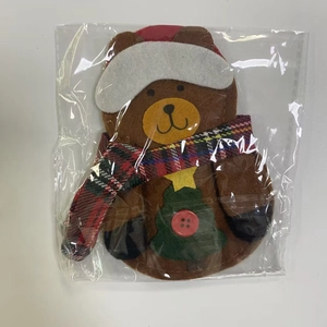 Detail of Christmas bear ornament with scarf and buttons in a transparent protective bag