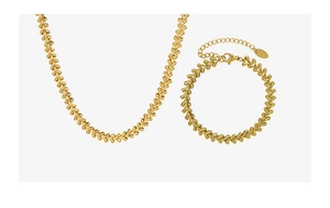 Close-up of golden leaf jewelry set with K18 gold purity hallmarks on white background