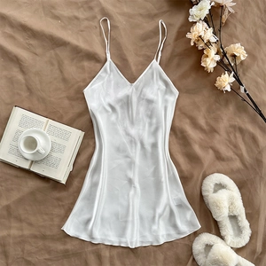 Eleganter weißer Satin-Schlafanzug mit dünnen Trägern in ästhetischer Umgebung