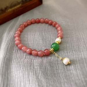 Detail of pink strawberry crystal bracelet with pearls and adjustable gold metal chain