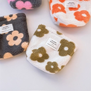 Detailed flat lay of plush floral pouches with sherpa texture and mayrabbit brand labels