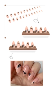Detail of almond press-on nails featuring black leaf patterns and gold foil flakes
