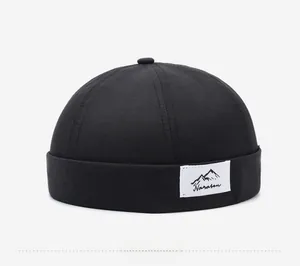 Detail of black cotton Docker hat featuring a Narason mountain logo woven label