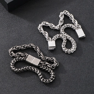Detailed close-up of chunky stainless steel curb chains in silver and gun black tones