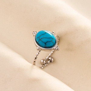 Macro shot of silver adjustable steel ring featuring an oval blue turquoise stone inlay