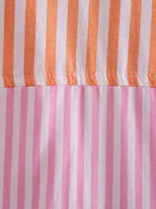 Detailed macro view of orange and pink striped patchwork fabric with fine stitching