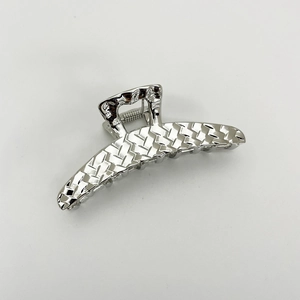Detailed view of large silver metal hair claw clip with a textured woven pattern