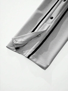 Detailed macro view of light grey knit joggers featuring side stripes and snap buttons