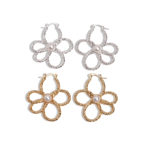 Goldene und silberne hohle Blumenohrringe mit Perlen auf einem klaren weißen Hintergrund