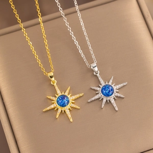 Gold and silver star necklaces with blue opal centers and crystals in a jewelry box