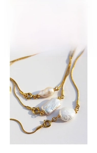 Detail of baroque pearl necklace with golden snake chain and spring clasp closure