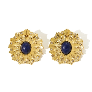 Detail view of gold earrings with blue center stone and small radiant crystals