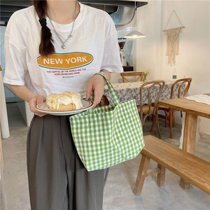 Detail of green and white plaid cotton linen handbag with a New York printed T-shirt