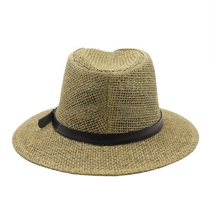 Detailed close-up of hollow straw weaving texture and dark brown leather decorative band