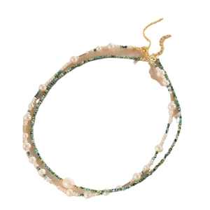 Double-layered natural pearl and turquoise necklace with gold accents on a white base