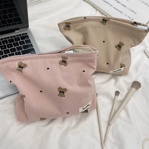 Detailed view of cute bear embroidery on corduroy cosmetic bags with zipper closure