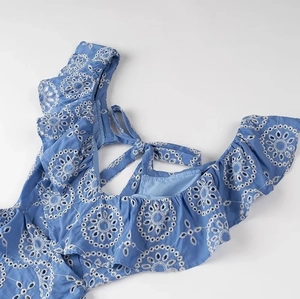 Detail of blue eyelet embroidery midi dress with ruffle trim and lace-up back design