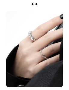 Detail of twisted rope and interlaced silver rings worn on finger with high shine finish