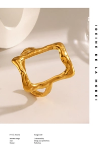 Detail of artistic gold wavy rectangular open ring with high-polished metallic texture