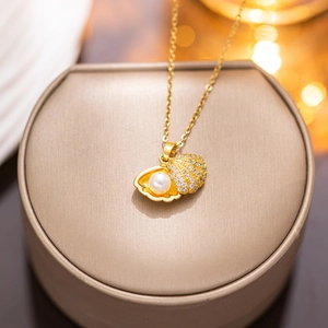 Golden shell necklace with pearls and rhinestones on jewelry box in warm lighting