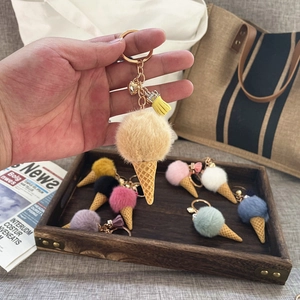 Detailed close-up of colorful plush ice cream cone keychains with golden clasps and tassels